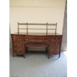 A George III mahogany sideboard with brass column gallery back over central bowed drawer flanked by