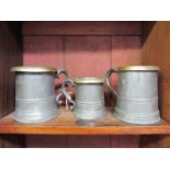 A pewter pint and half pint measure with brass rim both marked VR and similar pint measure