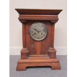 An early 20th Century oak mantel clock of architectural form with Arabic silvered dial,