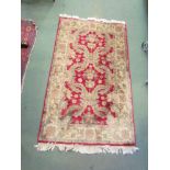 A modern red ground rug with floral pattern, tasselled ends,
