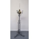 A wrought iron oil lamp stand with scroll and twist detail with "Matador" oil lamp