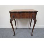 A walnut single drawer side table shaped front to carved cabriole legs