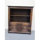 A "Titchmarsh & Goodwin" 17th Century revival oak bookshelf over two door cupboard with carved