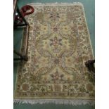 A gold ground rug with foliate decoration, tasselled ends,