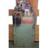 A late 19th Century domed top hall mirror with bevelled glass, floral embellishment,