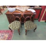 A circa 1840 pair of spoon back chairs with carved decoration over a button serpentine front seat