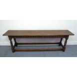 A 17th Century revival oak long bench the carved lunette frieze over turned legs joined by