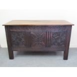 Circa 1760 an oak three panelled coffer the hinged lid over a carved front on stile feet