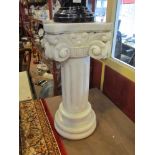 A carved marble pedestal of column form with scroll capital.