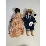 A black doll and a bisque head doll