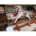 A vintage white washed wood and plaster childs rocking horse on pine base complete with red leather