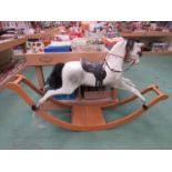 A white painted rocking horse on bowed rocker