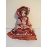 A double jointed bisque head doll with composition arms and legs in outfit.