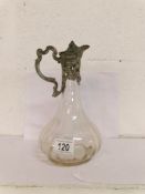 A glass claret jug with cast metal top