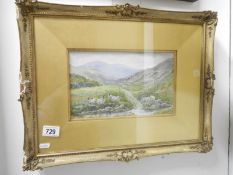 A framed and glazed watercolour of sheep by mountain