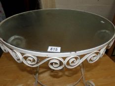 A wrought iron coffee table with glass top