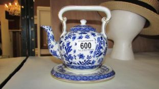 A 19th century blue and white teapot on stand
 
There is a crack in the handle above rear