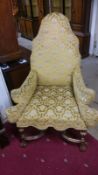 An early 19th century throne style chair with gilded legs and stretchers