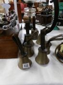 A set of 7 antique brass hand bells with leather straps,