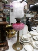 A Victorian brass column oil lamp with art nouveau pink glass font and later shade