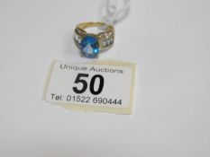 A 9ct gold ring set blue central topaz, pale topaz shoulders and pave' diamonds,