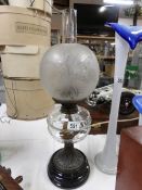 A Victorian oil lamp with glass font and etched shade