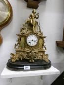 A brass clock surmounted figure