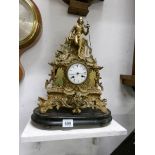 A brass clock surmounted figure