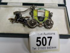 An unusual Victorian brooch depicting a coach and horses in enamel and silver