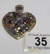 A large heart shaped 9ct gold pendant set approximately 22 carats of multicoloured sapphires,