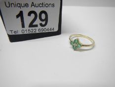 A 4 stone emerald and centre diamond gold ring, size L