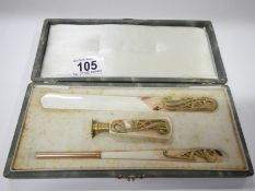 A cased art nouveau ivory and gilt desk set comprising pen, letter opener and seal