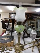 A Victorian brass corinthian column oil lamp with mottled green glass font and later shade