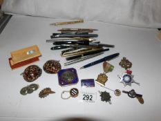 A collection of enamel badges including police and a quantity of pens
