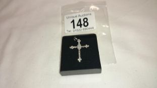 A brilliant cut white gold and diamond cross