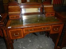 A satinwood and mahogany desk with green leather inset
