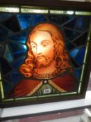 A stained glass panel depicting the head of Christ in an oak frames, approximately 20.5" x 20.5" (