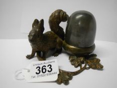 A cast metal inkwell being squirrel with nut
