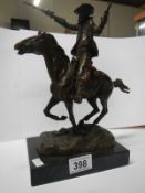 A bronze signed Kauba of a cowboy with rifle and pistol riding in to battle