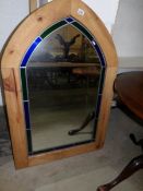 A pine framed and leaded arched mirror