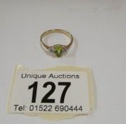 A yellow gold ring set peridot and diamonds,