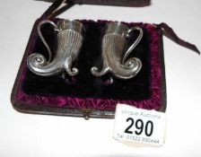 A cased pair of silver horn shaped pepperettes by Edgar Finlay & Hugh Taylor,