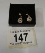 A pair of diamond and sapphire pear shaped gold earrings
