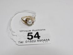 A 9ct gold ring set central pearl and shoulder rubies,