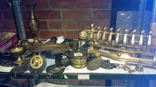 A shelf of brassware including horse brasses