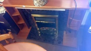 A teak fire surround with fire
