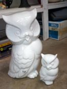 A large white pottery owl and a matching smaller owl