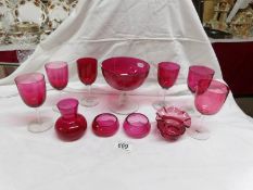 A set of 6 cranberry glass wine goblets and 5 other pieces of cranberry glass