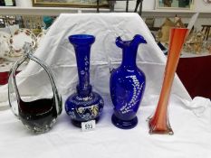 A hand decorated blue glass vase and ewer together with an art glass basket and a glass specimen