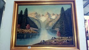 A gilt framed lake and mountain scene
